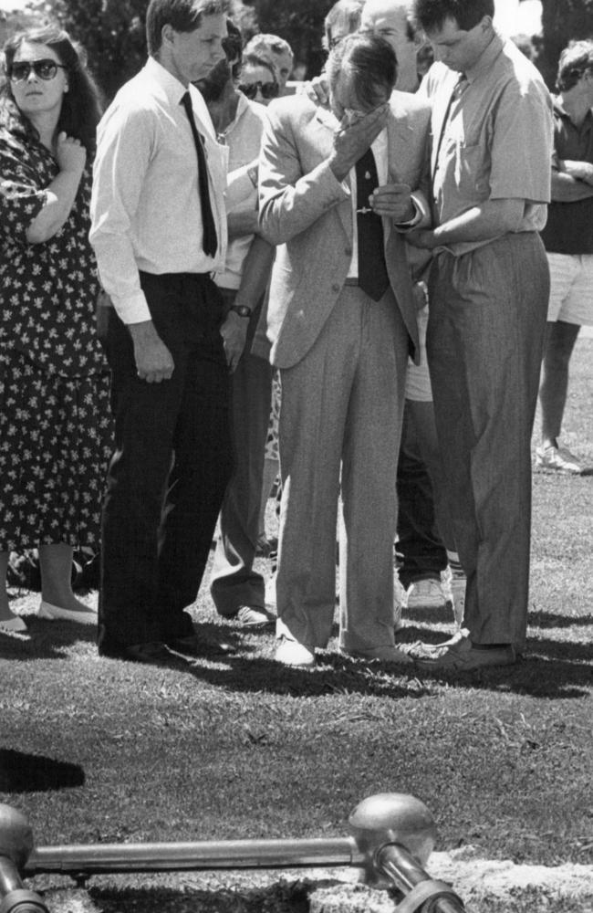 Ralph Vollmer is comforted at the grave site of his dead wife. Picture: Jamie Davies