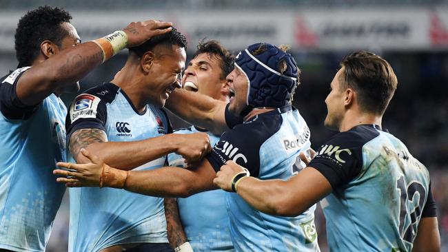 Israel Folau (2nd left) is congratulated by teammates after scoring for the Waratahs against the Brumbies on Sunday.