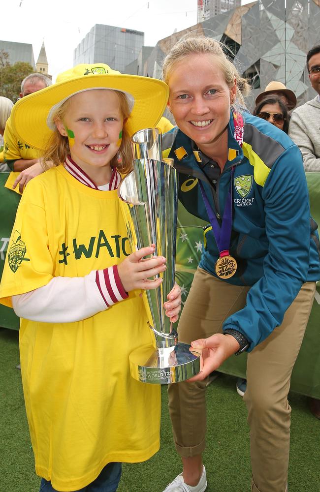 Skipper Meg Lanning shows off the trophy to a young fan.