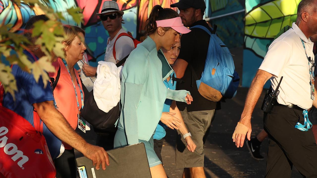 Andrea Petkovic is escorted from the court after retiring from her first round match. Photo: Mark Kolbe/Getty Images