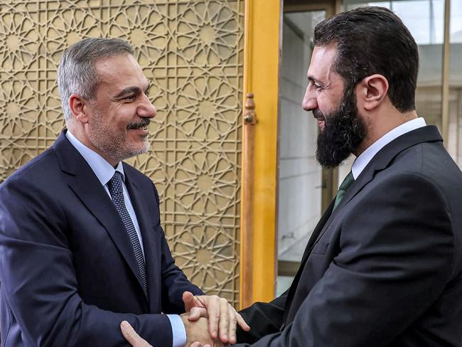 This handout picture released by the Turkish Foreign Ministry press service shows Turkey's Foreign Minister Hakan Fidan (L) being received by Hayat Tahrir al-Sham (HTS) leader Ahmed al-Sharaa (also known as Abu Mohammad al-Jolani), in Damascus on December 22, 2024. (Photo by TURKISH FOREIGN MINISTRY / AFP) / RESTRICTED TO EDITORIAL USE - MANDATORY CREDIT "AFP PHOTO / TURKISH FOREIGN MINISTERY PRESS SERVICE  " - NO MARKETING NO ADVERTISING CAMPAIGNS - DISTRIBUTED AS A SERVICE TO CLIENTS