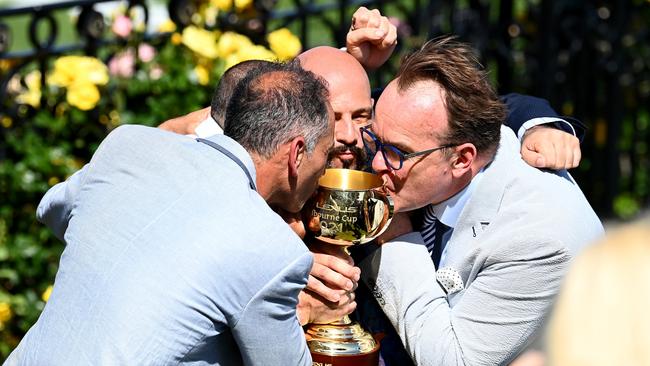 Mr Kheir kisses the Melbourne Cup with fellow connections. Picture: Getty Images