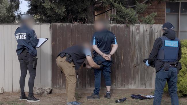 Police arresting a man in a Sydenham raid in connection with Operation Ironside.