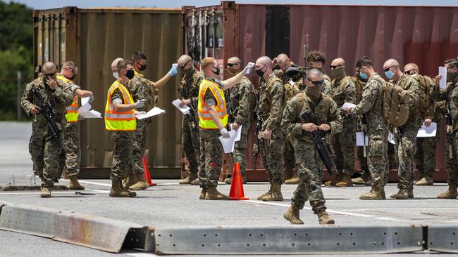 Members of the III Marine Expeditionary Force's COVID Task Force screen Marines with 3rd Battalion, 7th Marine Regiment at Kadena Air Base, Okinawa, Japan, May 15, 2020. The battalion will be quarantined for 14 days before attaching to Marine Rotational Force - Darwin as the ground combat element. As MRF-D arrives in Australia, all Marines and sailors will undergo another 14-day quarantine period. (U.S. Marine Corps photo by Cpl. Harrison Rakhshani)