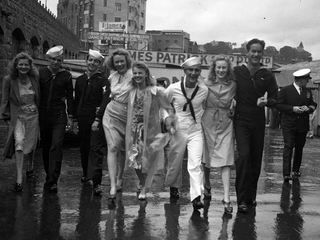 The crew of the US Submarine Sterlet walk arm-in-arm with local Brisbane girls in 1947.