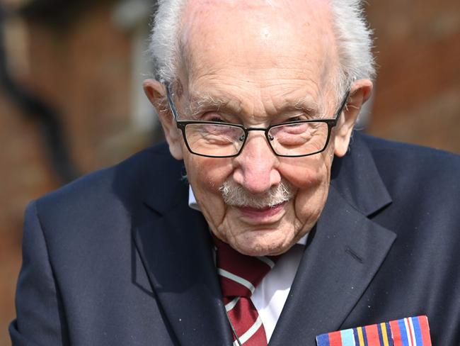 (FILES) In this file photo taken on April 16, 2020 British World War II veteran Captain Tom Moore, 99, poses doing a lap of his garden in the village of Marston Moretaine, 50 miles north of London, on April 16, 2020. - A World War II veteran who has raised millions of pounds for charity by walking around his garden on Friday became the oldest man to top the UK music charts -- just days from his 100th birthday. Captain Tom Moore had already become a global phenomenon for raising more than £28 million ($35 million, 32 million euros) for staff of the state-run National Health Service (NHS) battling the coronavirus outbreak. (Photo by JUSTIN TALLIS / AFP)