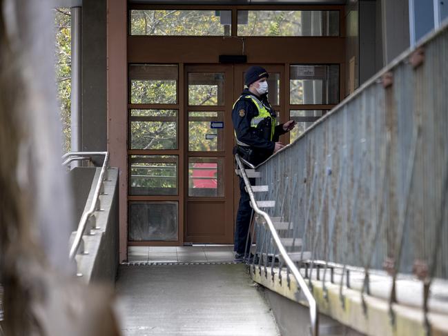 Police keep guard at the Flemington housing commission flats. Picture: Luis Enrique Ascui