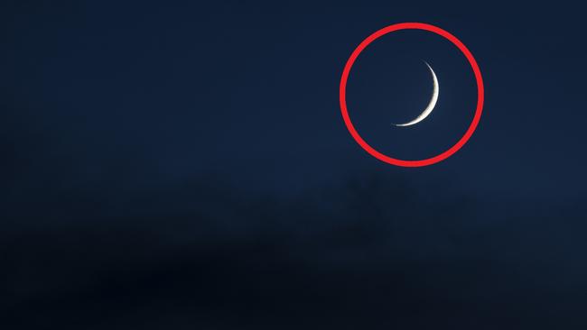 A crescent moon in a cloudy sky at night. Copy Space.