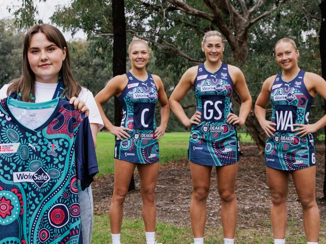 Proud Kamilaroi woman and artist Teagan Malcolm with the dress displaying the imagery she created for the Melbourne Vixens' First Nations round with (from left) Kate Moloney, Sophie Garbin and Hannah Mundy in the dress. Photo: Wiradjuri photographer Joshua Scott.