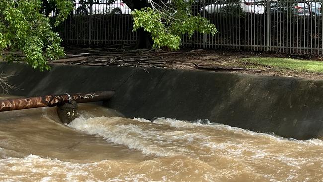 Water is rushing fast down a drain behind Hinkler Shopping Centre. The shopping centre was flooded in 2013.