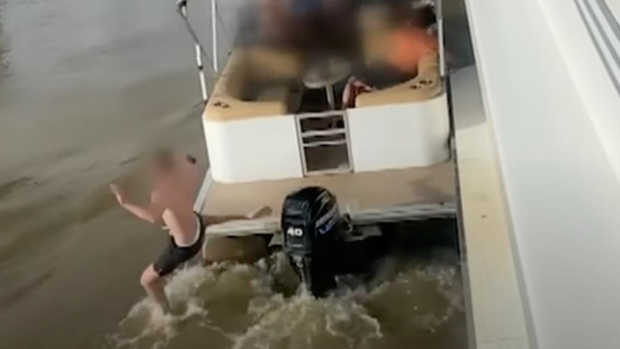 One of the men narrowly missed the outboard motor as he leapt back to his boat. Picture: 7NEWS