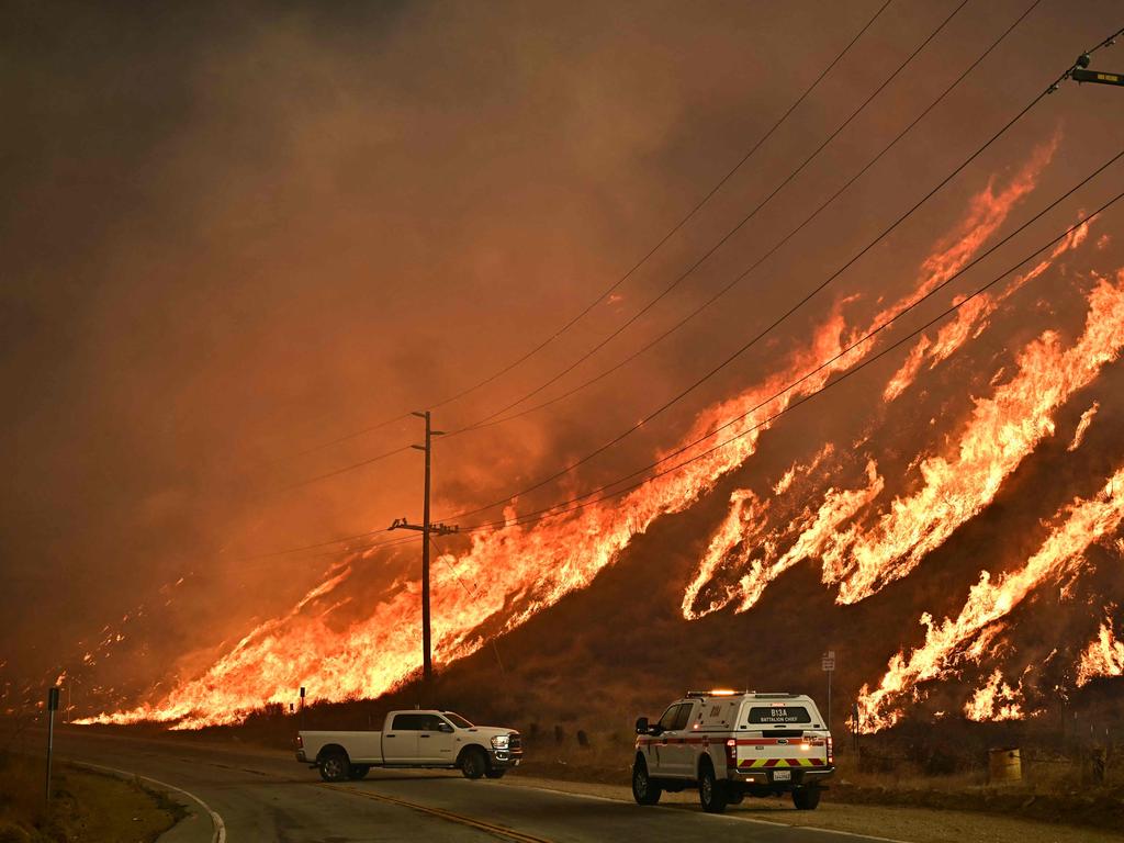 Emergency vehicles are on the side of the road as flames from the Hughes Fire race up the hill in Castaic, a northwestern neighbourhood of Los Angeles. Picture: AFP