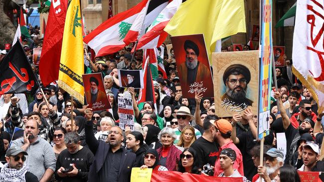 Protesters hold up pictures of dead Hezbollah leader Hassan Nasrallah and the Hezbollah flag at a protest at Town Hall in Sydney Picture: NewsWire / Damian Shaw