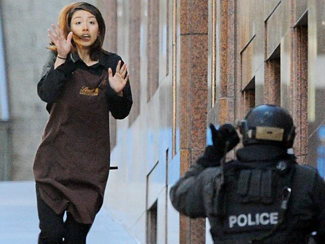 Hostage Elly Chen runs towards a TOU officer after escaping from the cafe. Picture: Joel Carrett