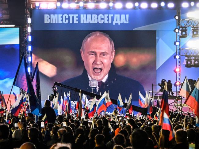 TOPSHOT - Russian President Vladimir Putin is seen on a screen set at Red Square as he addresses a rally and a concert marking the annexation of four regions of Ukraine Russian troops occupy - Lugansk, Donetsk, Kherson and Zaporizhzhia, in central Moscow on September 30, 2022. (Photo by Alexander NEMENOV / AFP)