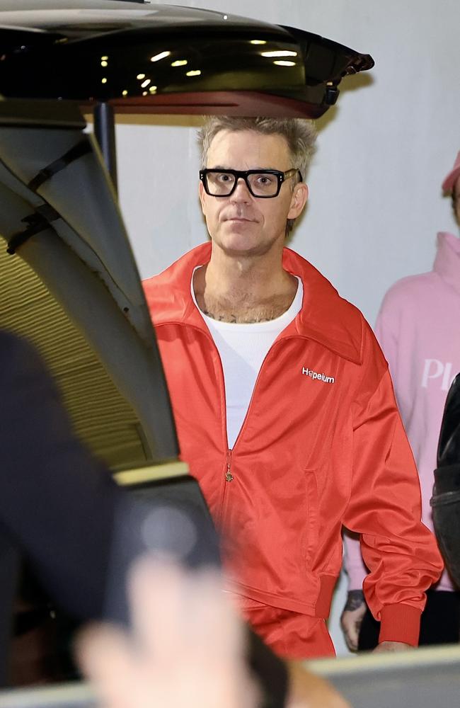 The singer kept it casual in a red tracksuit as he touched down on our shores. Picture: ©MEDIA-MODE.COM