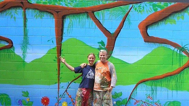 Nicola Bryars-Parker and Neil Parker in front of one of the murals they helped paint to brighten up Rusty’s Market. Picture: supplied.