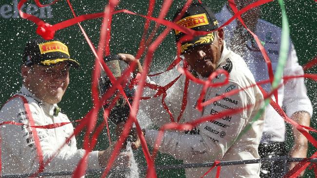 Mercedes driver Lewis Hamilton of Britain, center, winner of the Italian Formula One Grand Prix, celebrates with second placed Mercedes driver Valtteri Bottas of Finland, left, and third placed Ferrari driver Sebastian Vettel of Germany, at the Monza racetrack, Italy, Sunday, Sept. 3, 2017. (AP Photo/Antonoi Calanni)