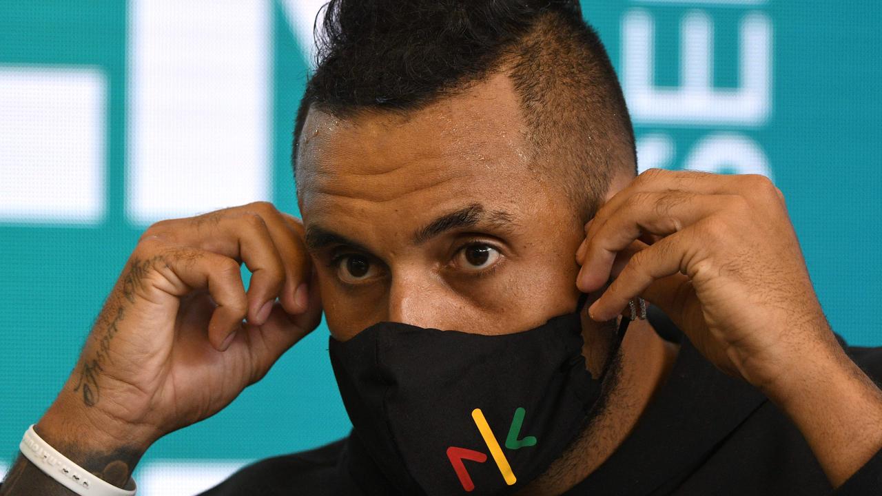 Nick Kyrgios adjusting his face mask as he speaks at a press conference. Picture: AFP