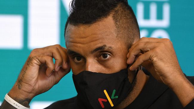 Nick Kyrgios adjusting his face mask as he speaks at a press conference. Picture: AFP