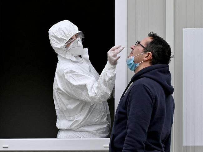 A medical worker takes a sample with a swab from a man, during a coronavirus test, at the Institute of Virology in Belgrade on December 24, 2020. Picture: AFP