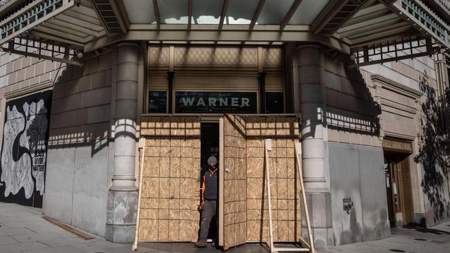 A workman boards up the windows of a Washington store. Picture: AFP