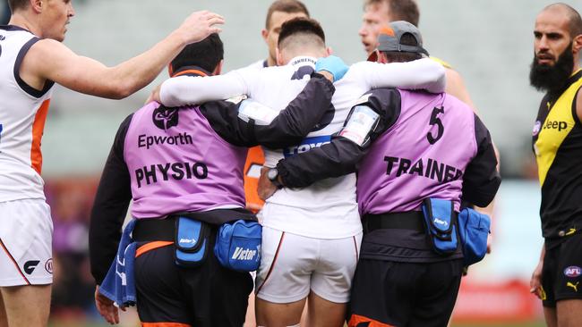 Stephen Coniglio is helped from the field after injuring his knee against the Tigers. Picture: Getty Images