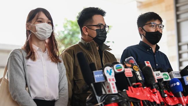 Pro-democracy activists (L-R) Agnes Chow, Ivan Lam and Joshua Wong speak to the media after arriving for their trial at West Kowloon Magistrates Court in Hong Kong on November 23. Picture: AFP