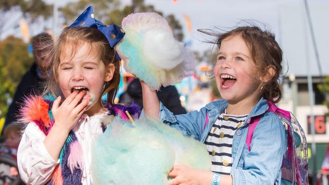 Twins, Tahlia and Sienna McPhee, 4, tuck into some fairy floss. Picture: Sarah Matray