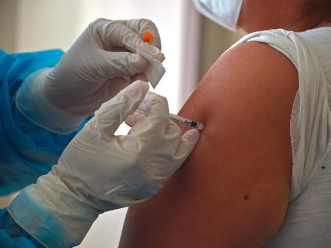 A woman is inoculated with the Pfizer vaccine against COVID-19 at the Pablo Arturo Suarez Hospital in Quito on January 21, 2021. - Ecuador received Wednesday the first 8,000 doses of vaccines against COVID-19, becoming the second South American country, after Chile, to use the inoculation developed by the German-US alliance Pfizer/BioNTech. (Photo by RODRIGO BUENDIA / AFP)