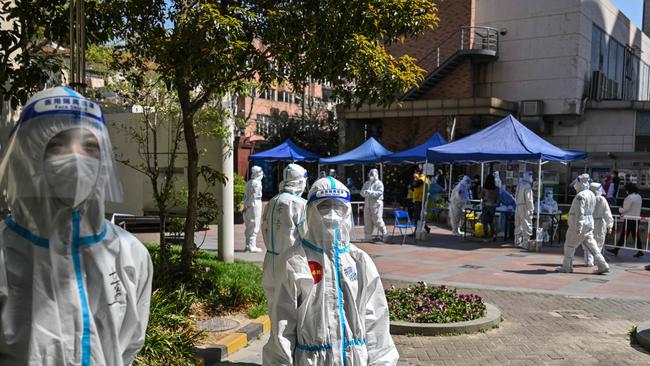 Workers and volunteers look on in a compound where residents are tested for the Covid-19 coronavirus. Picture: AFP