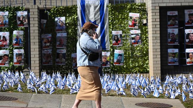 A woman walks past the Israeli embassy, near pictures of hostages in Gaza, in Washington. Picture: AFP.