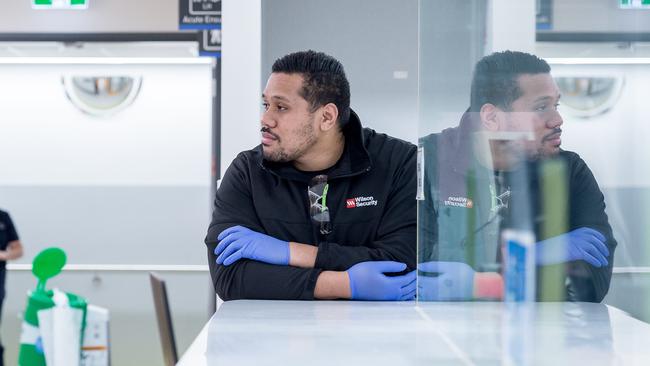 Security guard Danny Vini keeps a watchful eye on an agitated patient. Picture: Jake Nowakowski