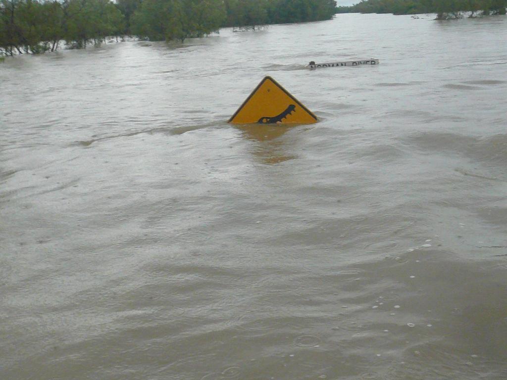  The barely visible crocodile warning sign at flooded Normanton.