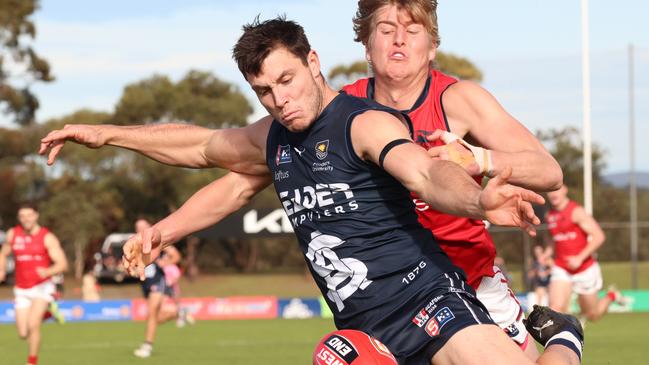 South Adelaide’s Liam Fitt gets his kick away under pressure from Norwood’s Jack Heard at Noarlunga Oval on Monday. Picture: Russell Millard Photography