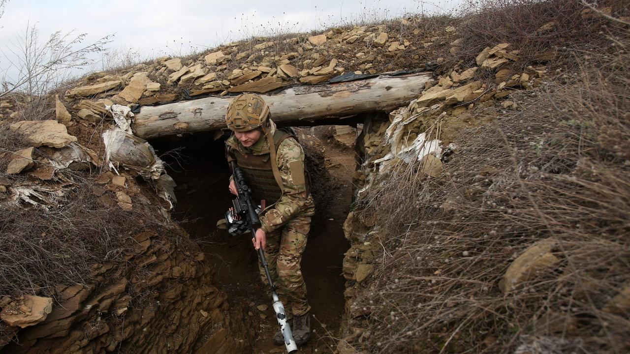 A Ukrainian serviceman walks along a trench at a position on the front line with Russia-backed separatists near the settlement of Troitske in the Lugansk region. Picture: AFP