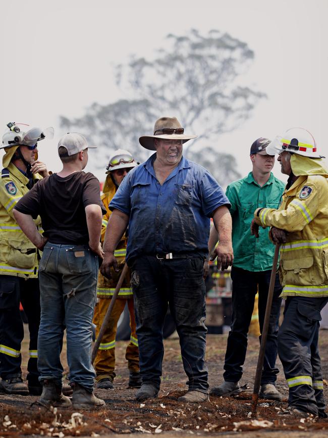 Mr Salway talks to RFS members form Byron Bay after the bushfire swept through his property. Picture: Adam Yip