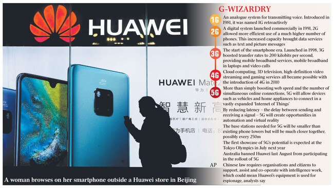 A woman browses on her smartphone outside a Huawei store in Beijing