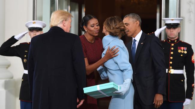 Double kiss: the Obamas welcome the Trumps. Picture: AFP