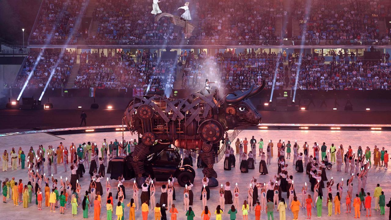 Performers remove the headpiece of The 'Raging Bull' during the opening ceremony