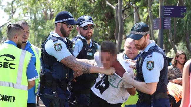 Police at the FOMO music festival remove a man from the area. Picture: David Swift.