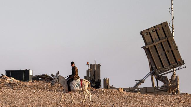 A boy on a donkey near one of Israel’s Iron Dome missile defence batteries. Picture: AFP