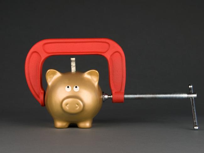 A golden piggy bank is being squeezed for its last dollar.  Image can be used for many financial inferences, including recessuion; savings; economy; retirement; investment and poverty. mortgage home loan spending pain generic