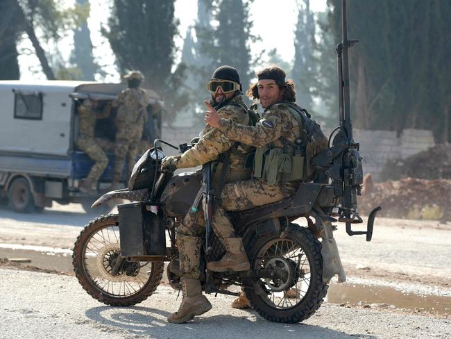 Jihadists drive on the international M5 highway in the area Zarbah  which was taken over by anti-government fighters on November 29, 2024, as Hayat Tahrir al-Sham (HTS) jihadists and allied factions continue their offensive in Syria's northern Aleppo province against government forces. The jihadists along with Turkey-backed factions launched this week a shock offensive against Syrian regime troops and sparked the deadliest battle the country has seen in years, with the violence killing so far 242 people, according to the Syrian Observatory for Human Rights. The war monitor said most of the victims were combatants on both sides but also including civilians. (Photo by Rami al SAYED / AFP)