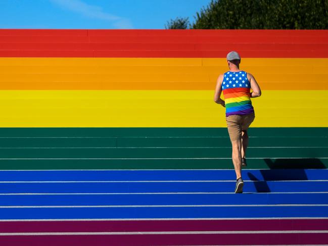 A man walks on steps covered in rainbow colours. Picture: AFP