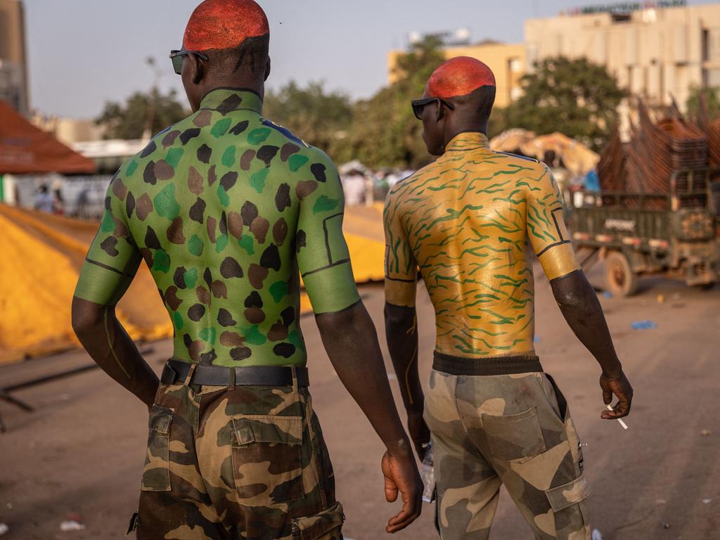 Men with military body painting walk during a gathering to show support to the military in the capital of Burkina Faso, Ouagadougou. Picture: AFP