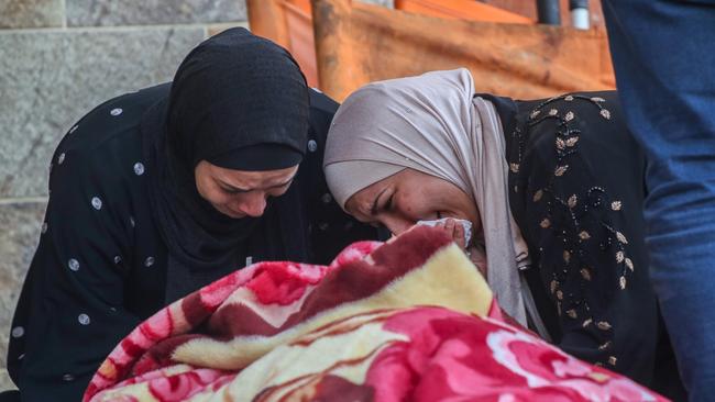 Two women cry as they mourn while collecting the bodies of Palestinians killed in an air strike Picture: Ahmad Hasaballah