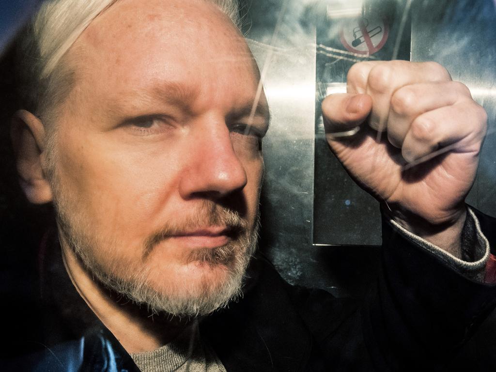 WikiLeaks founder Julian Assange gestures from the window of a prison van as he is driven to court in London in 2019. Photo: AFP.