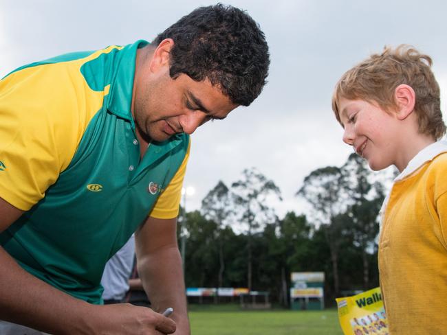 The Classic Wallabies hold a coaching clinic at Lismore Rugby Club ahead of their fixture against the Barbarians in Lismore on October 24. Morgan Turinui signs an autograph. Photo: Stuart Walmsley/RUGBY.com.au