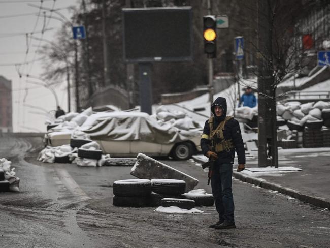 An armed man stands at a road block in downtown Kyiv. Picture: Aris Messinis / AFP